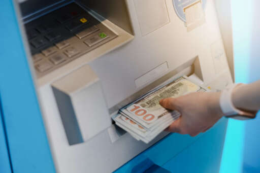 Closeup woman withdrawing money from ATM, 24h service, easy banking operation